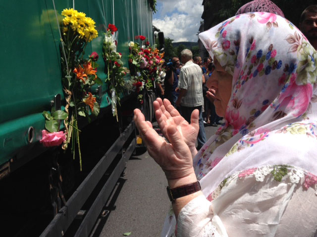 Visoko - Eine Frau betet vor dem LKW mit den Särgen für Srebrenica - Foto: BR | Eldina Jasarevic