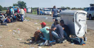 Sommerhitze ohne Schatten. Ermüdete, durstige Menschen suchen sich den kargen Schutz einer Mülltonne. Foto: BR | Attila Poth
