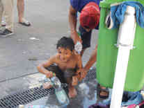 Kinder werden über einem Abfluss gewaschen. Foto: BR | Attila Poth