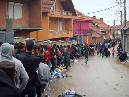Die Menschen warten entlang der Dorfstraße von Miratovac auf Busse, die sie ins Durchgangslager in Presevo/Serbien bringen. Foto: BR | Schaban Bajrami