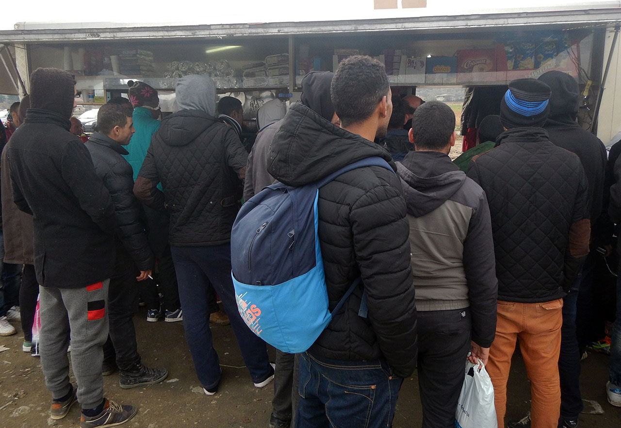 Die Flüchtlinge warten geduldig an der Imbissbude auf das Ende des Wutausbruches. Foto: BR | Schaban Bajrami