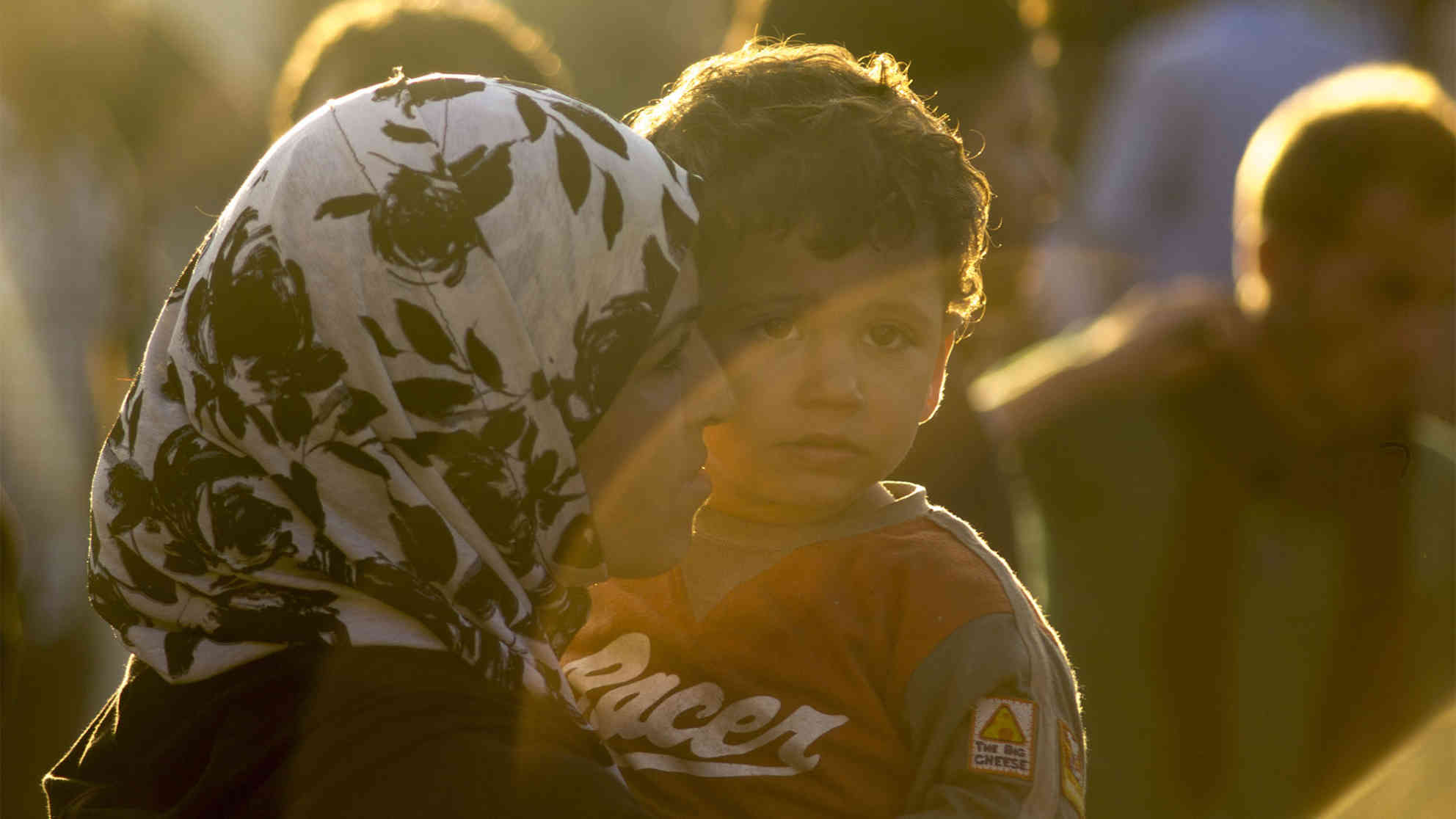 Mutter, die ihren Jungen im Sonnenuntergang hält. (Gevgelija, August 2015). Foto: BR | Besnik Hamiti