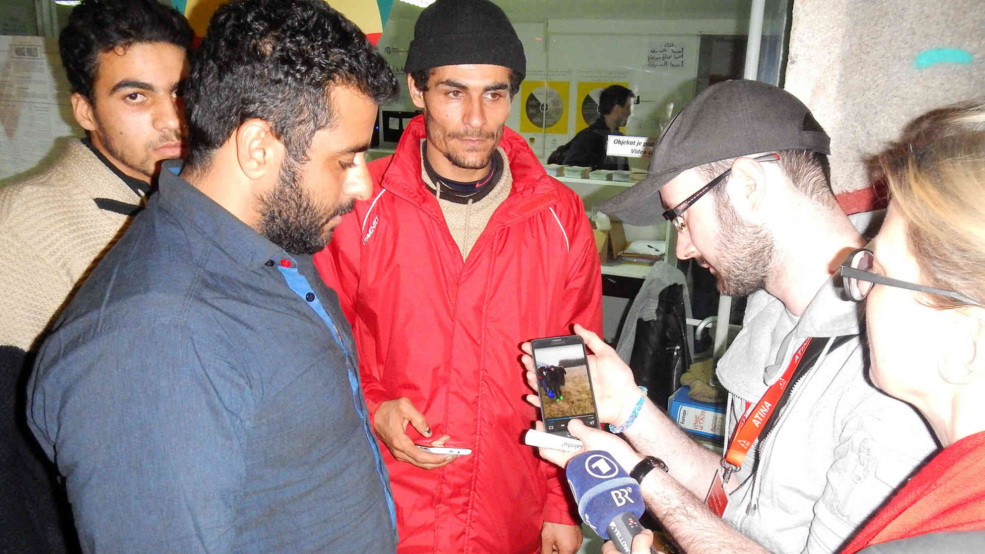 Mohmad (im blauen Hemd) und Jusuf (Mitte) zeigen uns mit Handys gedrehte Videoaufnahmen von ihren vergeblichen Versuchen, die serbisch-kroatische bzw. serbisch-ungarische Grenze zu passieren. Foto: BR | Dejan Stefanovic