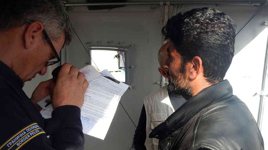 Die mazedonischen Polizisten nehmen die Dokumente der Flüchtlinge genau unter die Lupe. Foto: BR | Schaban Bajrami
