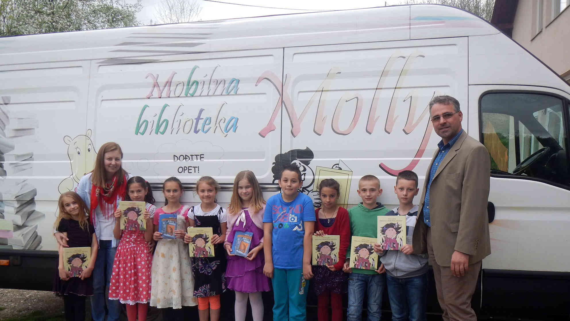Die Schule in Lipljani hat nur 17 SchülerInnen. Hier zu sehen die 3. und 4. Klasse mit ihrer serbischen Englischlehrerin Aleksandra Milovanovic (2.v.l.) und Molly-Fahrer Nerzudin Hajdarevic. Aufgrund der hohen Arbeitslosigkeit - von diesen neun Kindern hat nur ein Vater einen Job - verlassen viele die Region und versuchen in der EU Fuß zu fassen. Foto: BR | Eldina Jasarevic