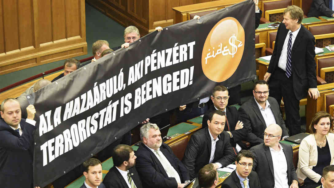 Jobbik-Abgeordnete halten nach der Abstimmung ein Transparent mit der Aufschrift ´Ein Vaterlandsverräter ist, wer Terroristen für Geld ins Land lässt!´ Foto: picture-alliance | dpa