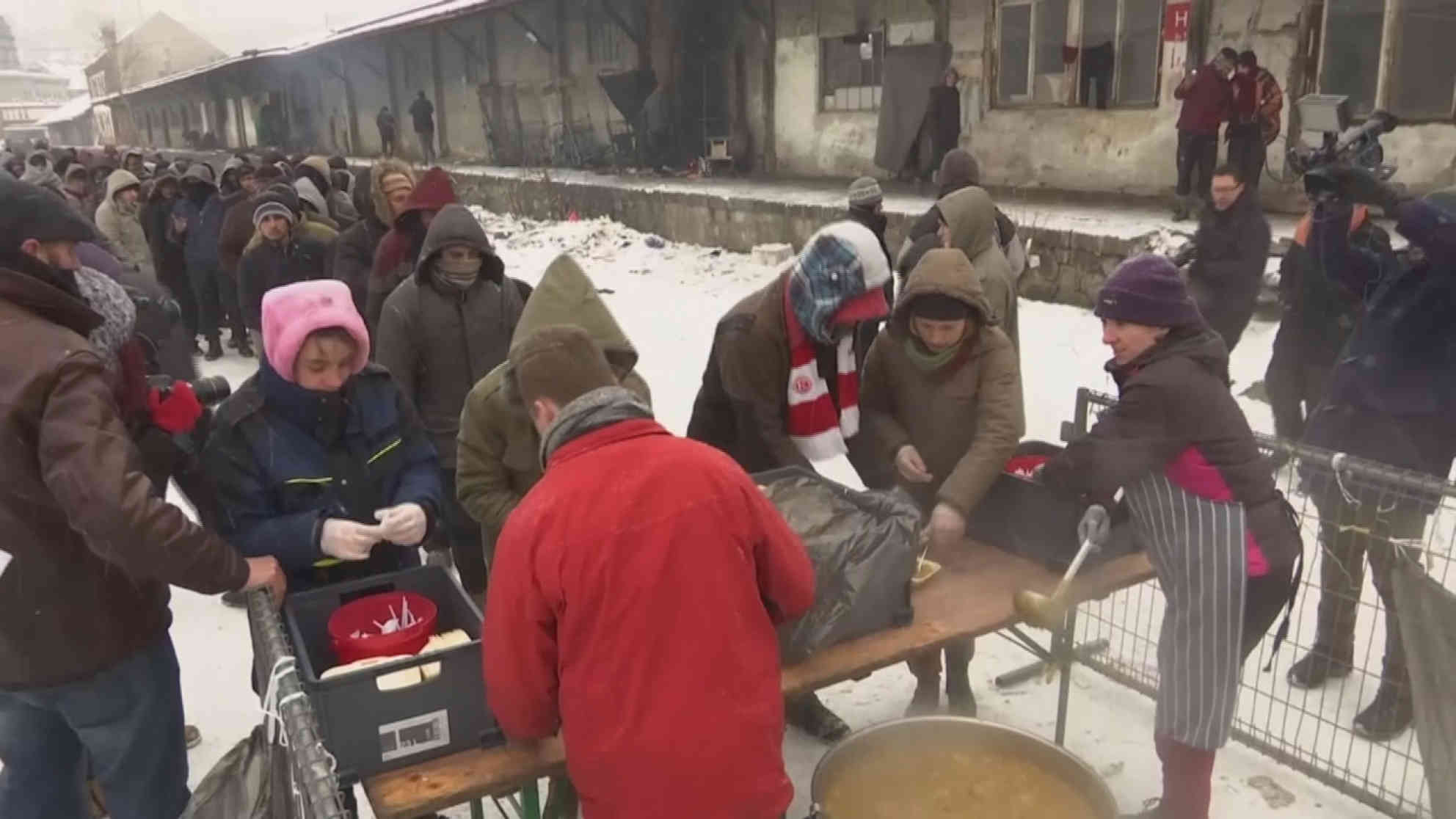 Vor den verlassenen Lagerhäusern hinter dem Belgrader Hauptbahnhof verteilt eine Hilfsorganisation Essen an die sich dort aufhaltenden Flüchtlinge. Foto: eurovision/ap | Videostandbild