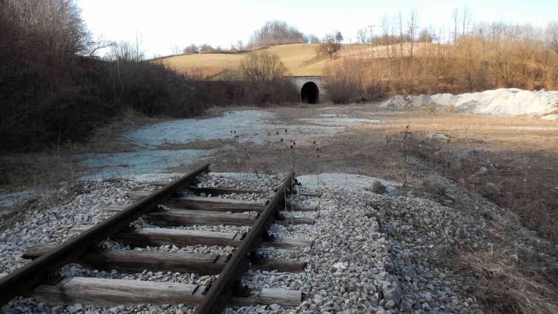 Schauplatz des politischen Missbrauchs von 1998 im Dorf Kamenica anlässlich der Einweihung eines der längsten und kompliziertesten Tunnels. Die 300 Meter Schienen, die auf dem Plateau des künftigen Bahnhofs gelegt wurden, blieben ironischerweise auch der einzige fertige Abschnitt der Strecke. Zeitzeugen berichten, dass zu dem Zeitpunkt nicht mal der Tunnel wirklich fertig war. Der Durchbruch vor den Kameras des Staatsfernsehens soll inszeniert worden sein. Foto: BR | Dejan Stefanovic