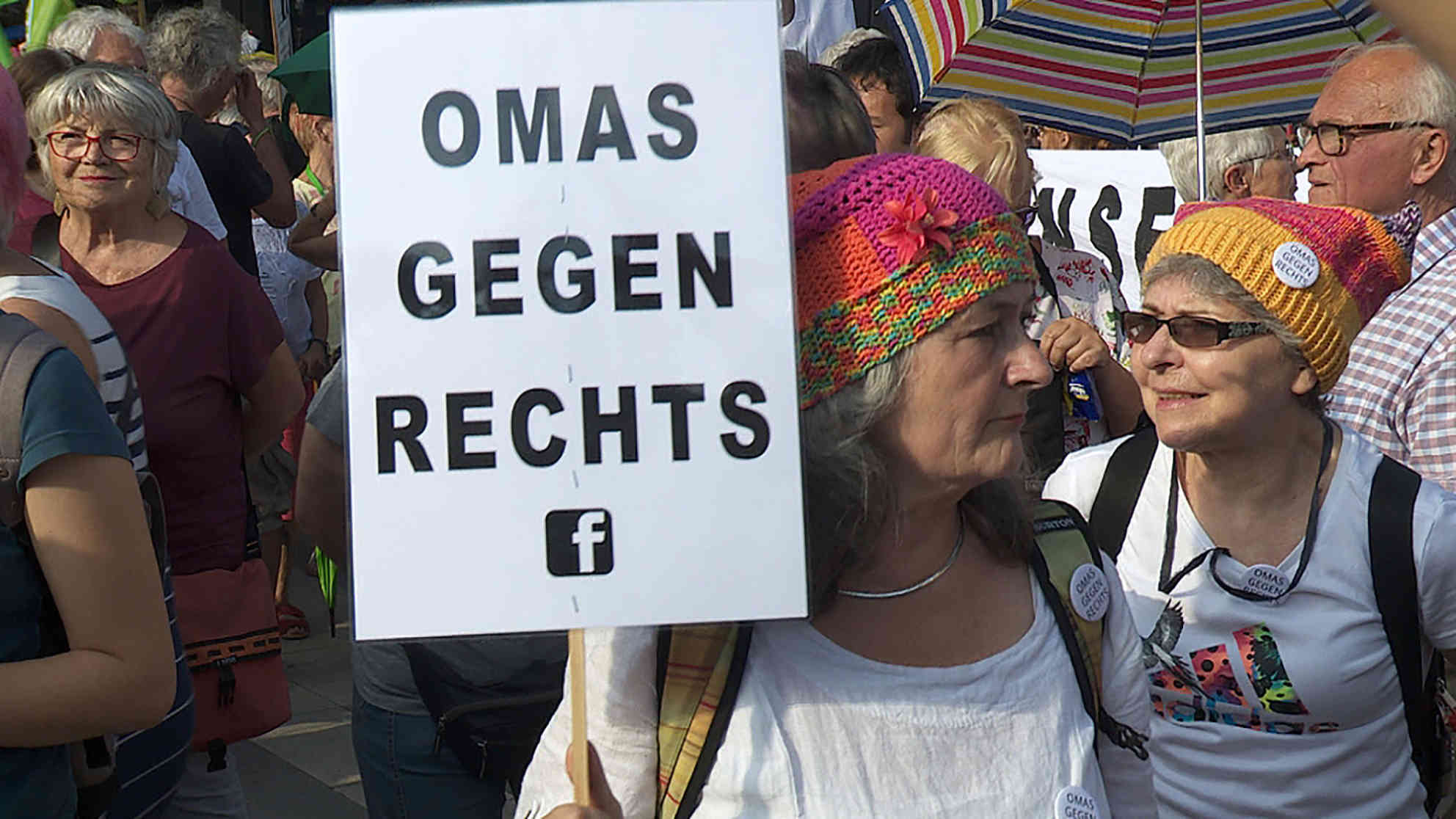 'Omas gegen Rechts' - selbstgestrickte Mützen sind ihr Erkennungszeichen. Foto: BR | Videostandbild | Daniel Dzyak