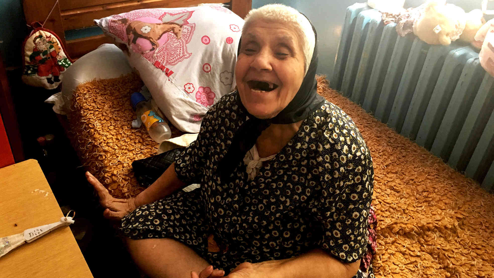 Olga M. wird ‚Mama‘ genannt. Die fröhlich wirkende Frau lebt in der Pflegestation und hat eine Tochter. Diese hat auch eine Behinderung und lebt in einem Heim in Skopje. ‚Morgen kommst du wieder‘, sagt Olga zum Abschied und lacht. Foto: BR | Andrea Beer