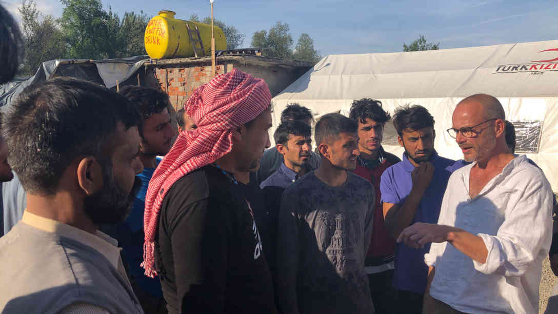Dirk Planert (rechts im Bild) im Gespräch mit Flüchtlingen die sich im Camp aufhalten. Foto. BR | Eldina Jasarevic