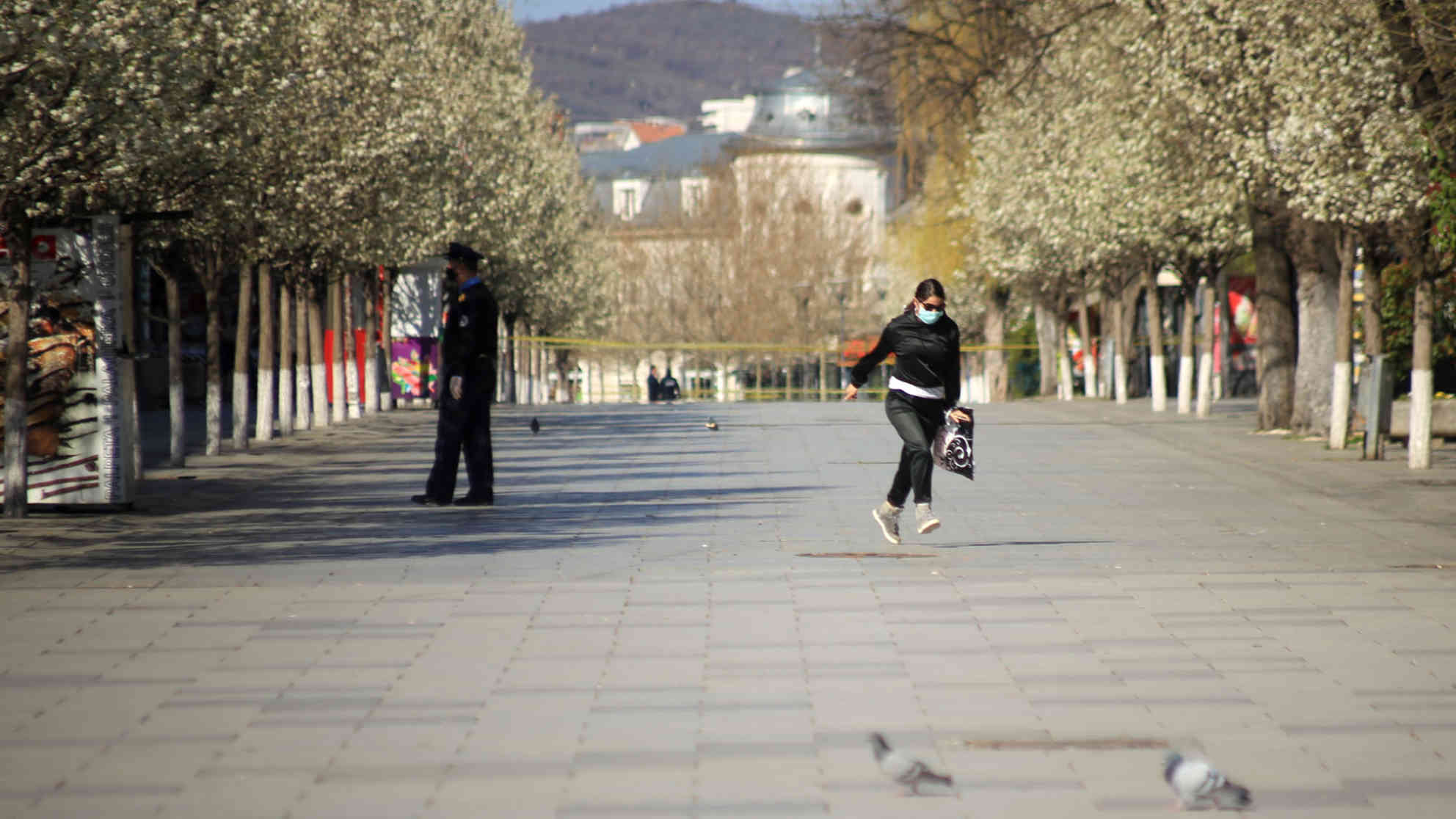Eine Frau läuft über die gesperrte Mutter Theresa Straße. Foto: BR | Besnik Hamiti