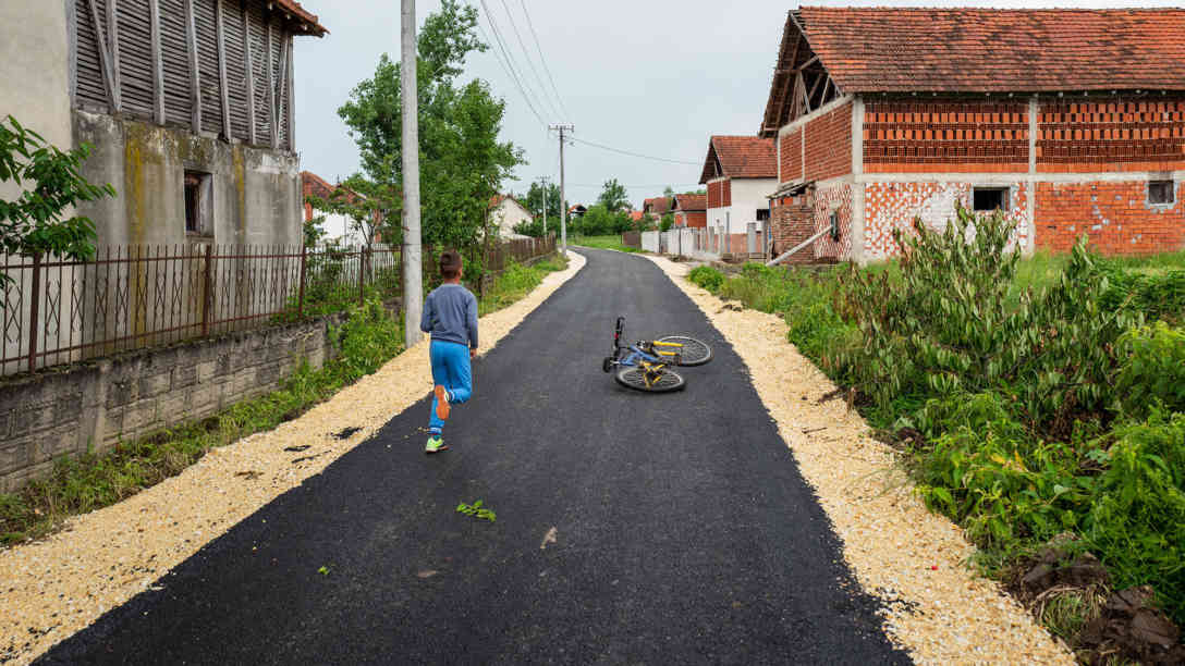 Wo früher eine mit Schlaglöchern übersäte Matschpiste war, ist im südserbischen Dorf Kukulovce jetzt eine frisch asphaltierte Straße. Foto: BR | Srdjan Govedarica