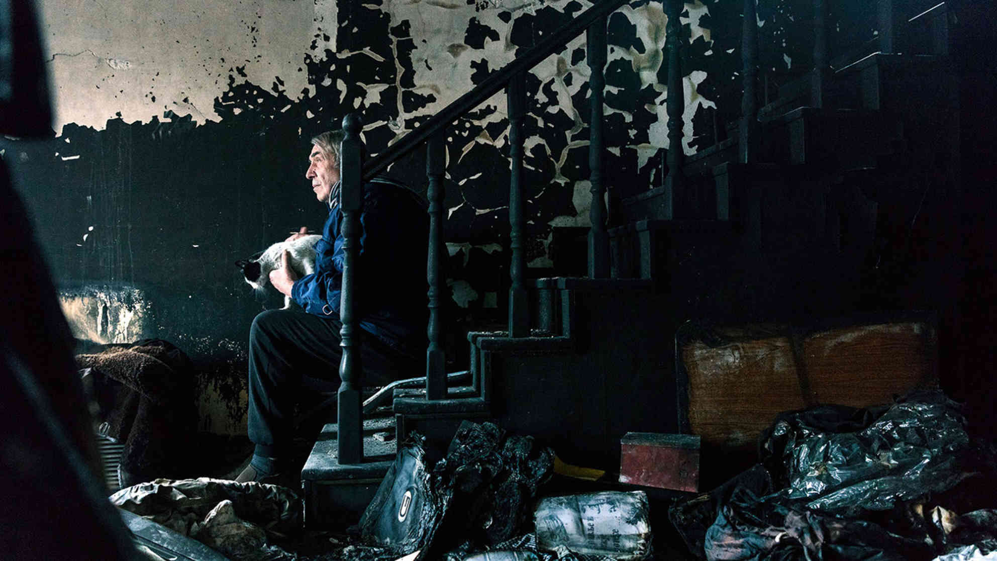 Milan Jovanović auf der Treppe seine ausgebrannten Hauses. Am 12. Dezember 2018 wurde ein Brandanschlag verübt. Er und seine Frau kamen nur knapp mit dem Leben davon. Foto: Marko Risović / Cenzolovka